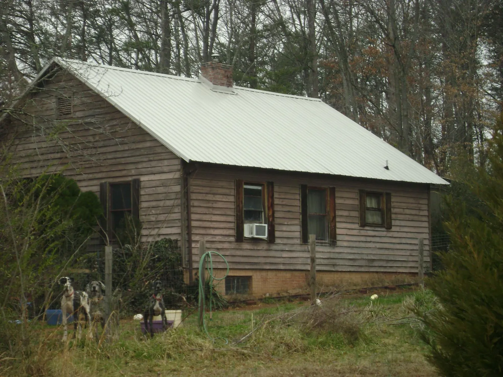 White metal roof on an old wood sided farmhouse, from a Metal Roof Installation job in Lufkin